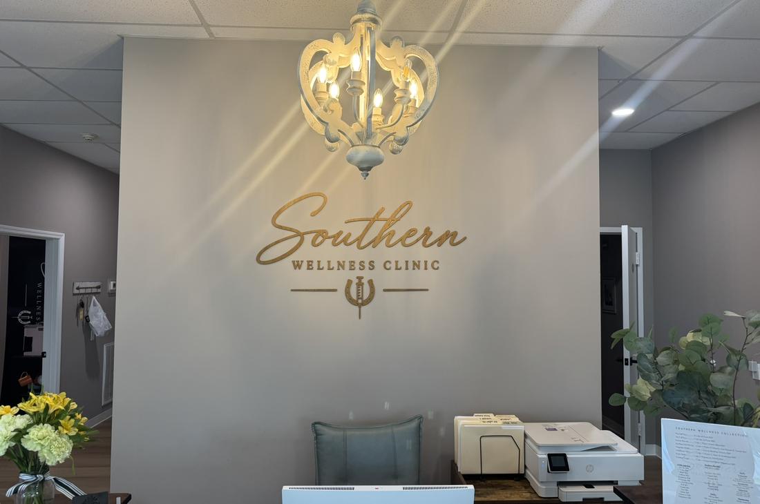 Southern Wellness Clinic reception with gold logo wall